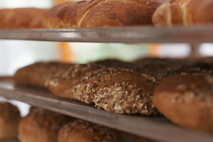 Gebackene Brote liegen auf dem Blech in der Bäckerei.