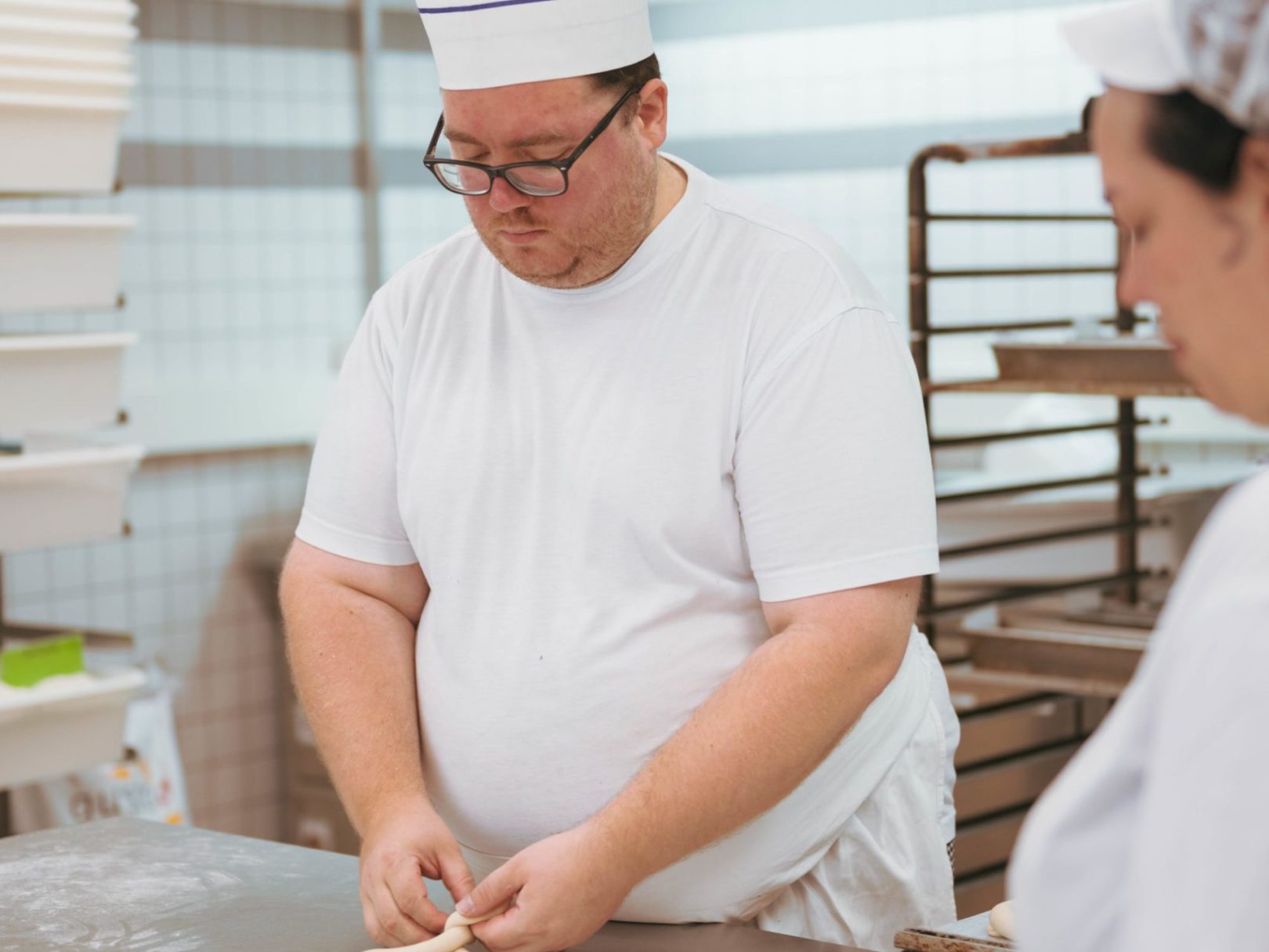 Ein Mann und eine Frau formen Teig in der Bäckerei.