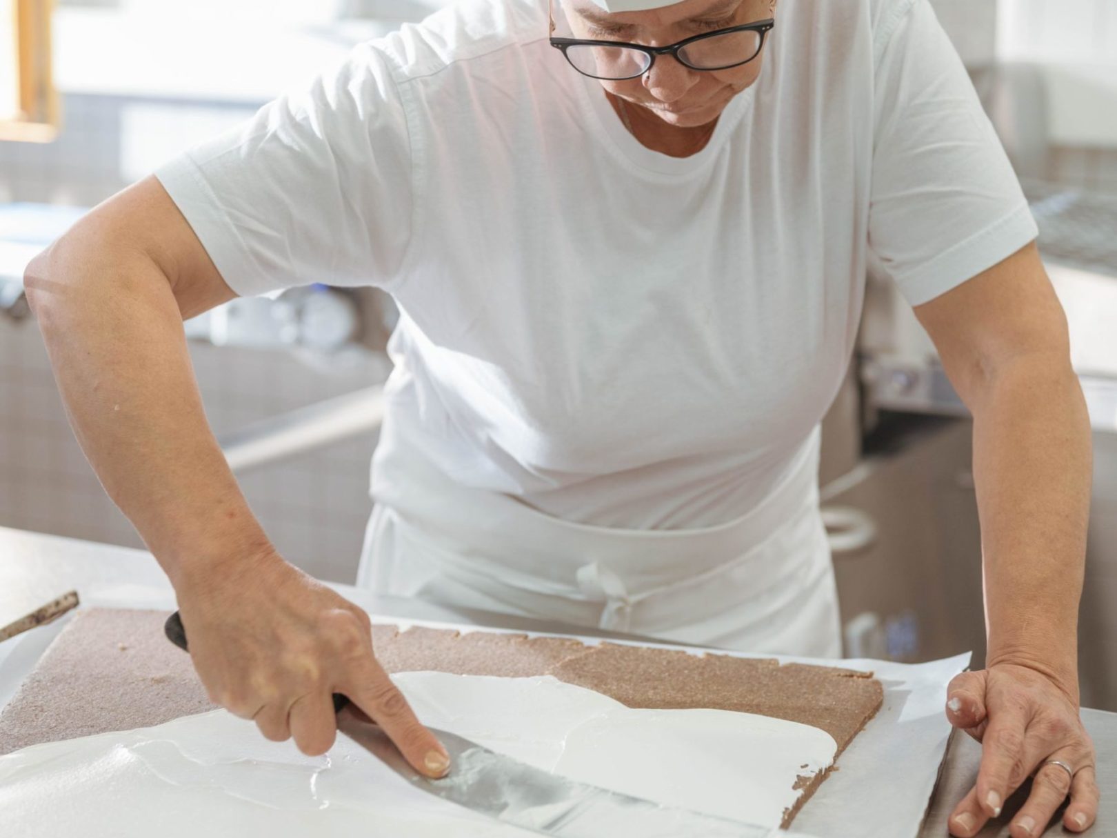 Eine Frau arbeitet in der Backstube einer Bäckerei.