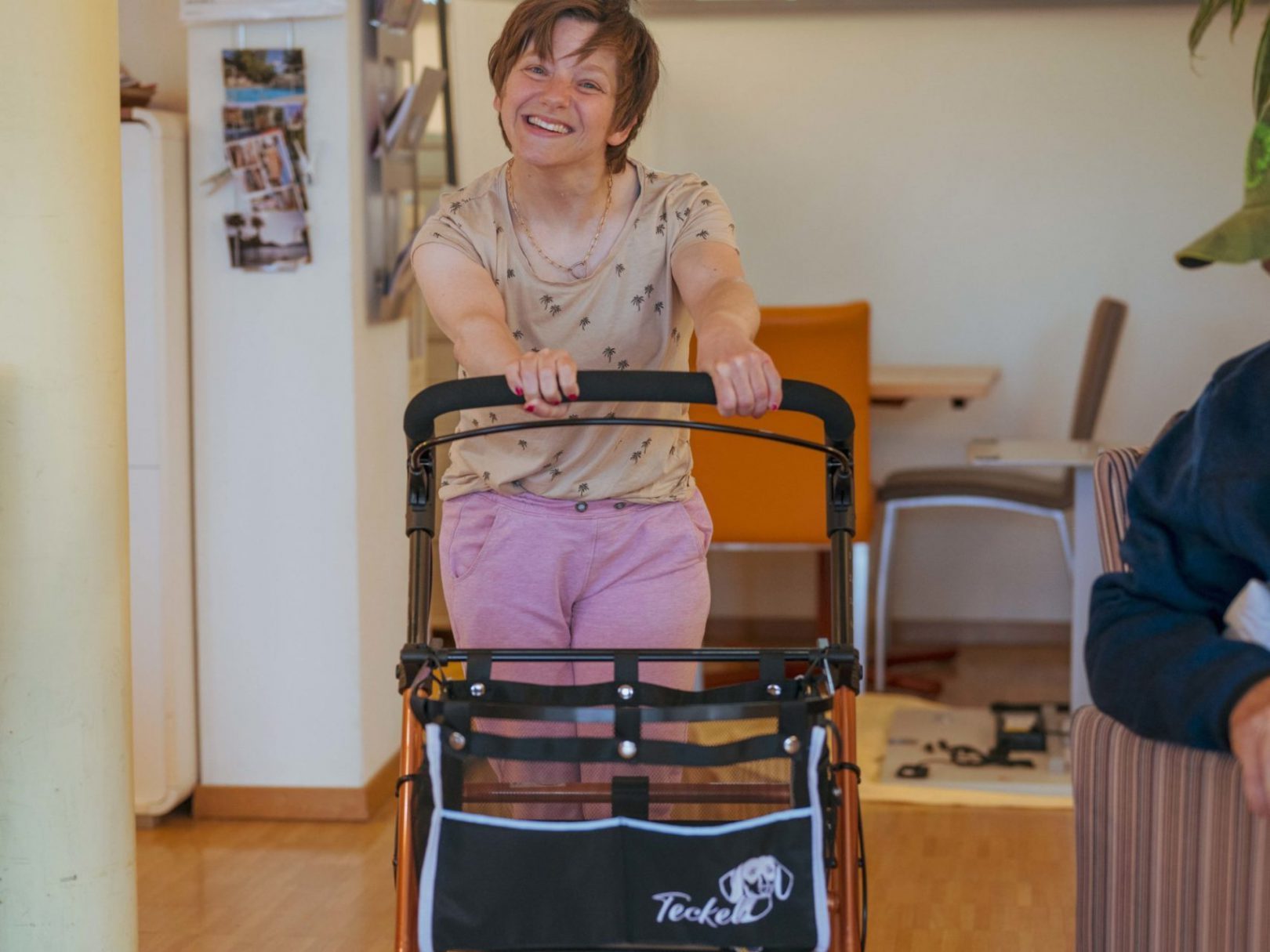 Eine Bewohnerin schiebt einen Rollator durch einen Aufenthaltsraum des Wohnhauses Brühlberg .