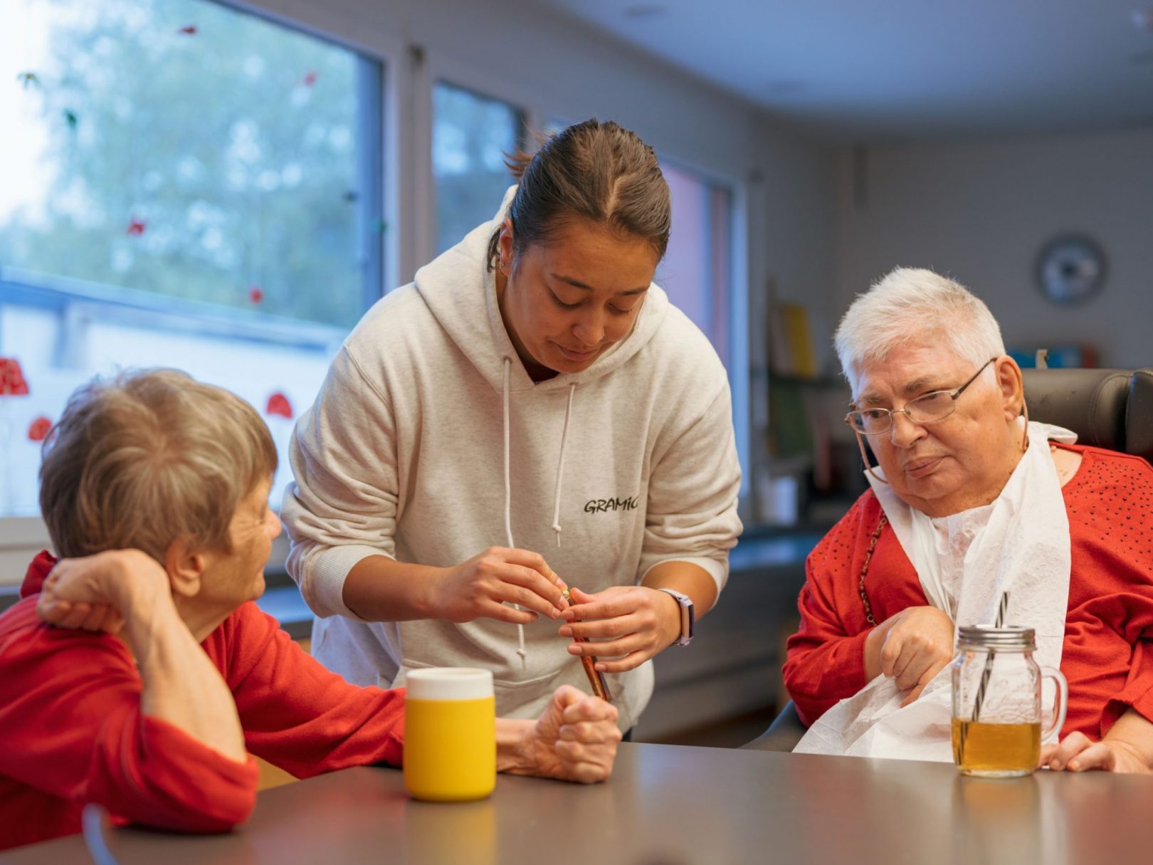 Drei Frauen sitzen an einem Tisch vor einem Getränk im Wohnhaus Wyden.