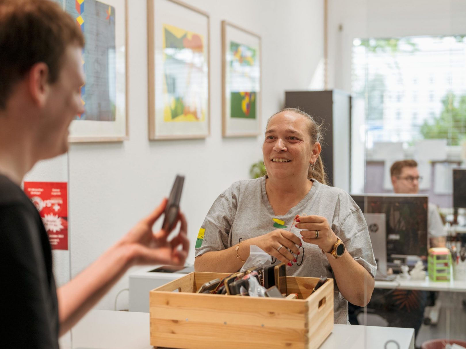 Zwei Personen im Fundbüro, welche sich Fundgegenstände anschauen