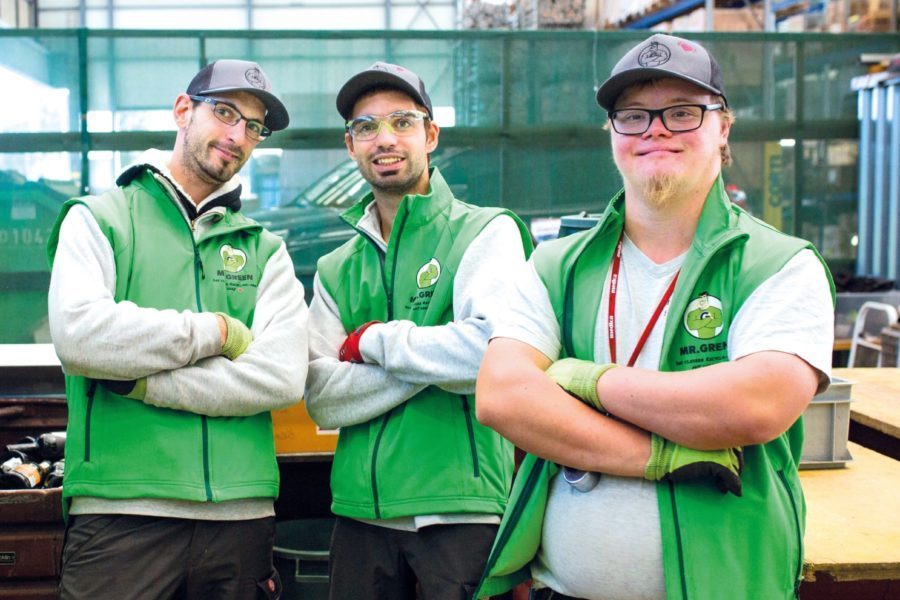 Drei Männer mit Arbeitskleidung aus unserem Mr. Green Recycling Team stehen da mit verschränkten Armen.