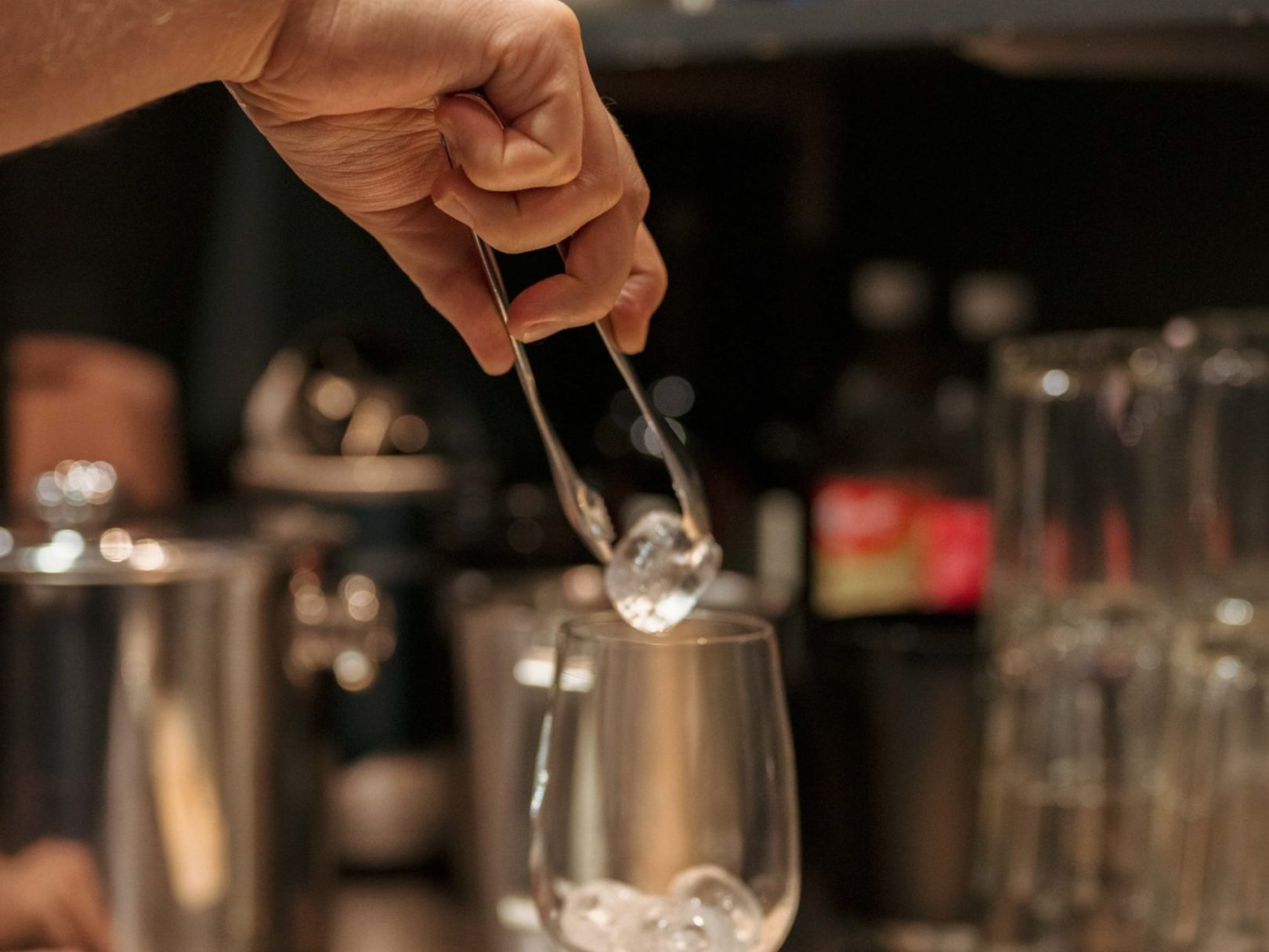 Ein Angestellter platziert ein Eiswürfel in ein Glas