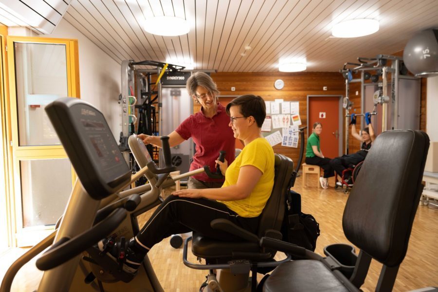 Eine Frau in der Physiotherapie auf einem Trainingsgerät.