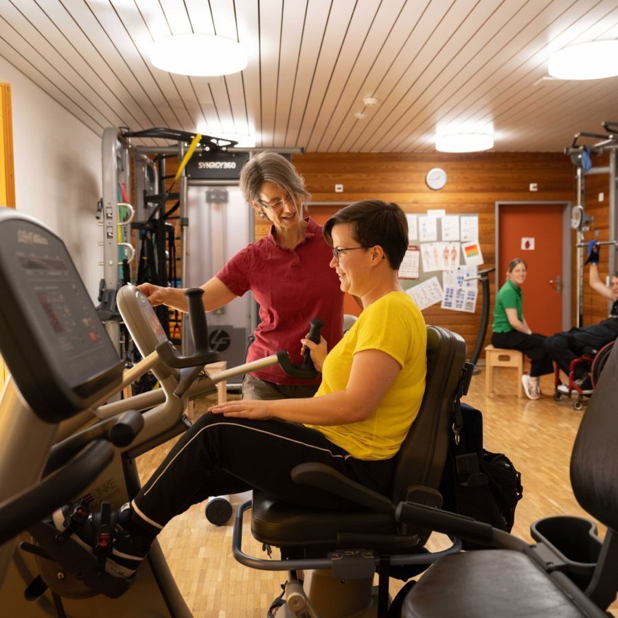 Eine Frau in der Physiotherapie auf einem Trainingsgerät.