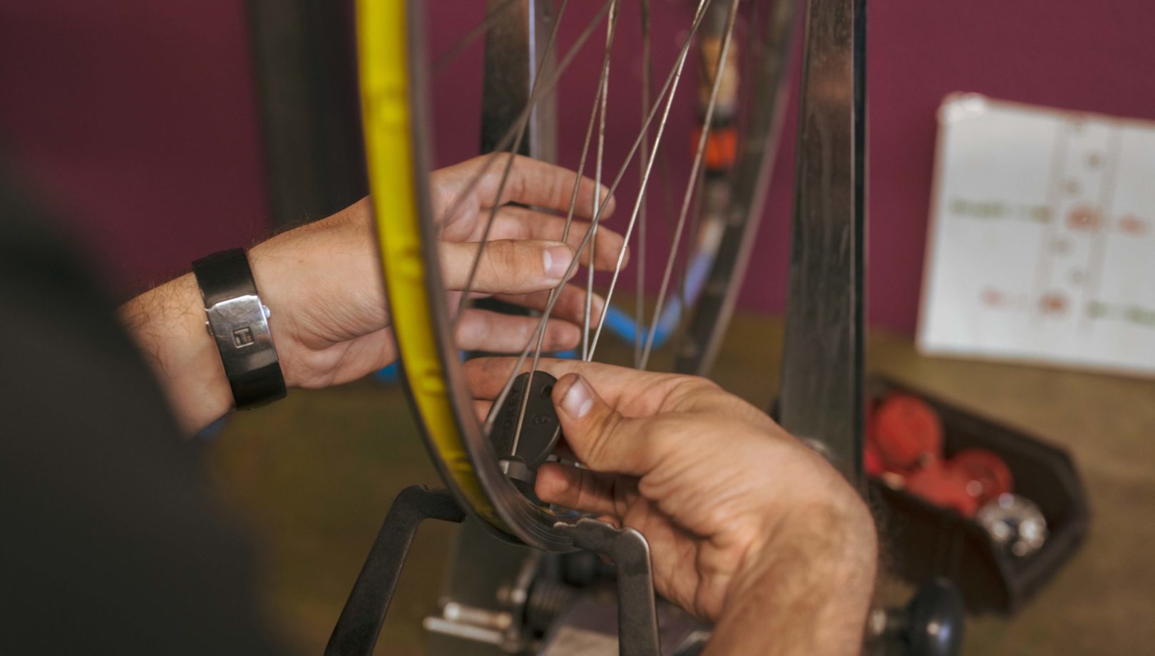 Ein Mann repariert das Rad eines Fahrrades in der Velowerkstatt.