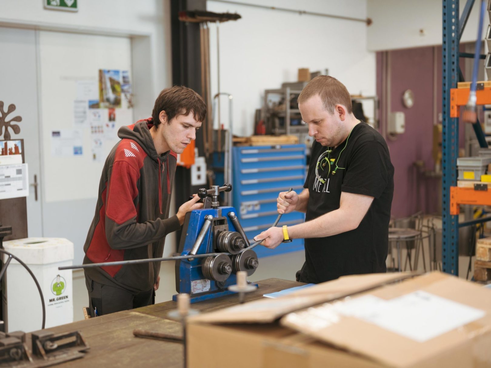 Zwei Männer arbeiten in der Werkstatt an einer Maschine.