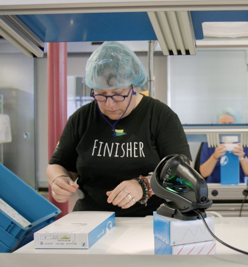 Zwei Personen arbeiten mit Verpackungen in einer Fabrik.