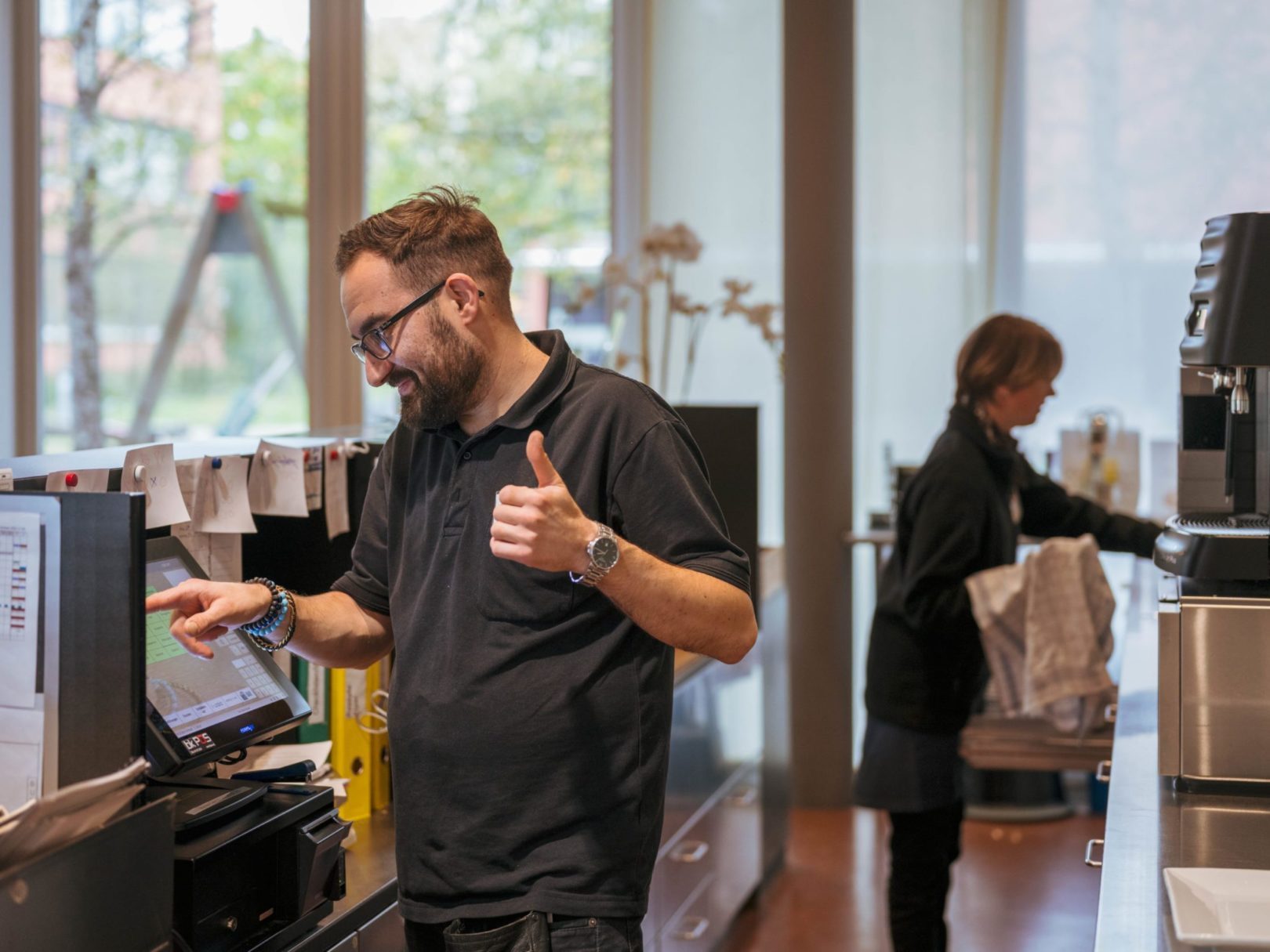 Zwei Angestellte arbeiten hinter dem Tresen im Café Wyden.