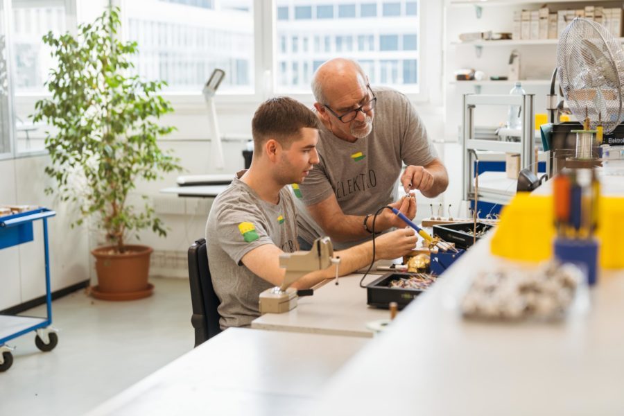 Zwei Männer arbeiten in einem Arbeitsraum an der Elektronik.