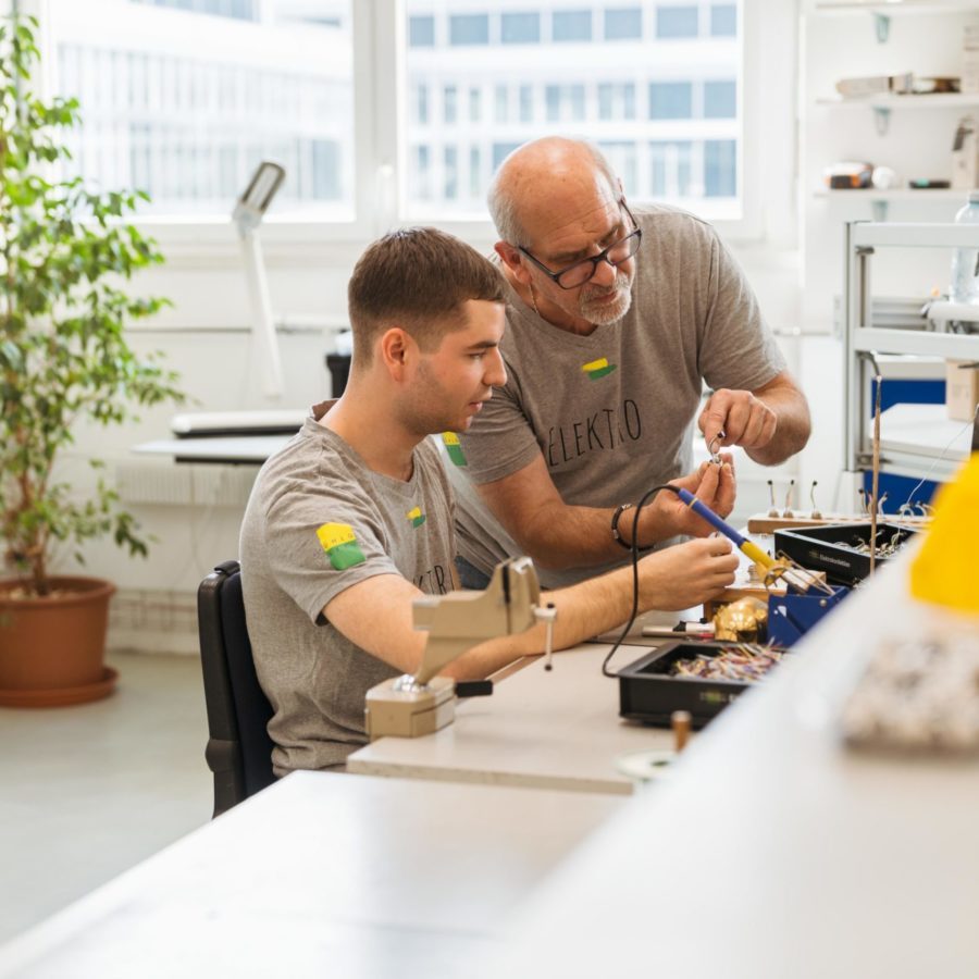 Zwei Männer arbeiten in einem Arbeitsraum an der Elektronik.