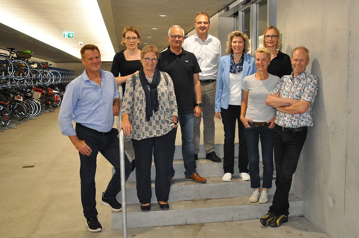 Die Personen des Stiftungsrats der Brühlgut Stiftung stehen als Gruppe auf einer grauen Treppe in einem Velokeller.