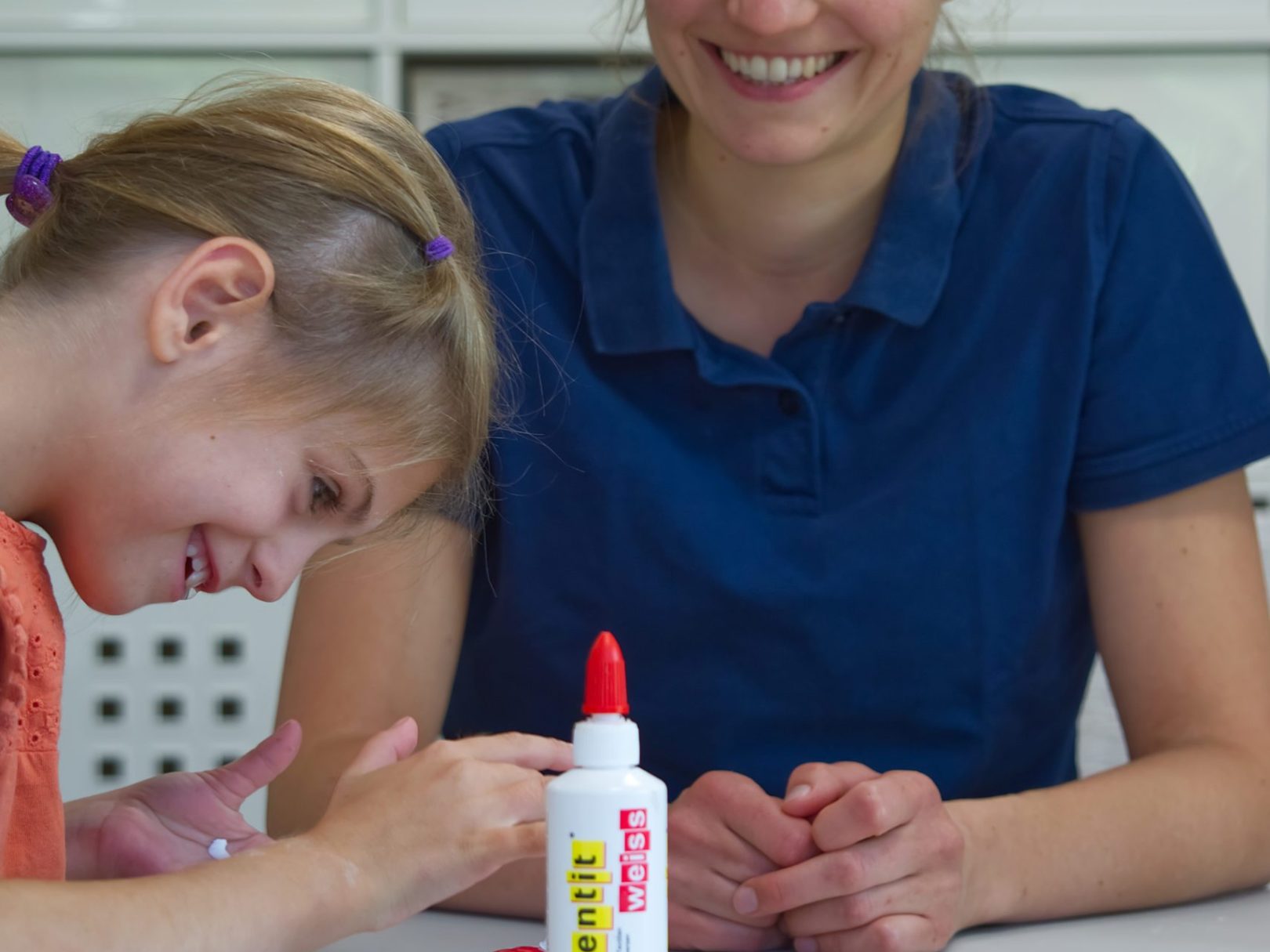 Ein Mädchen bastelt in der Therapiesitzung mit der Ergotherapeutin.