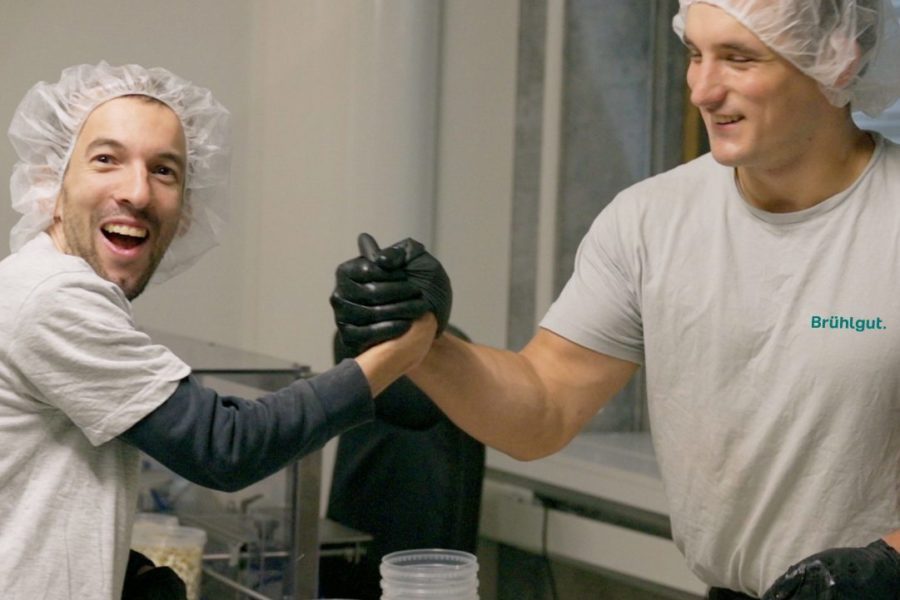 Zwei Männer machen Popcorn und klatschen sich mit den Händen ab.