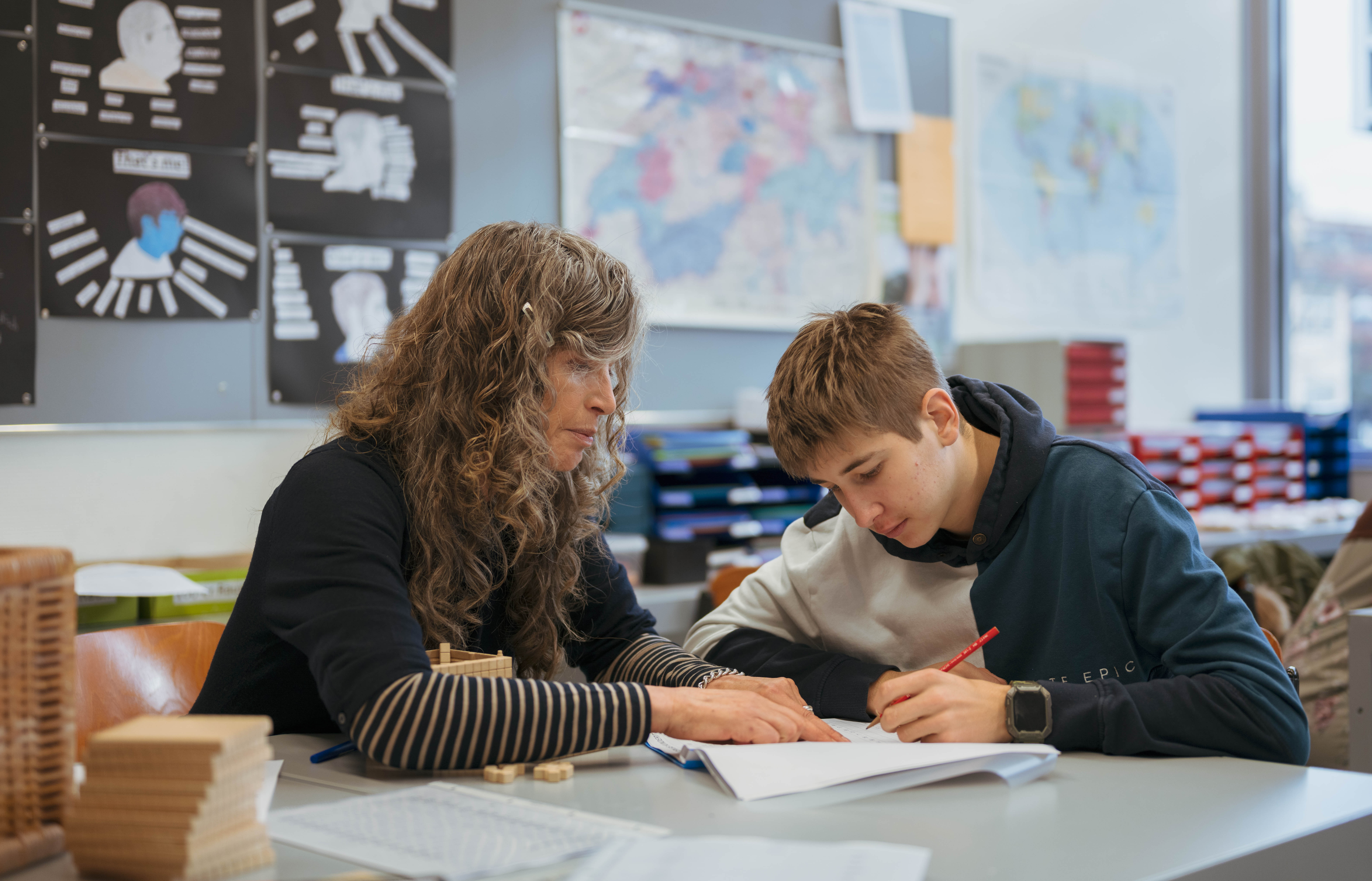 Eine Lehrerin hilft einem Schüler bei einer Aufgabe