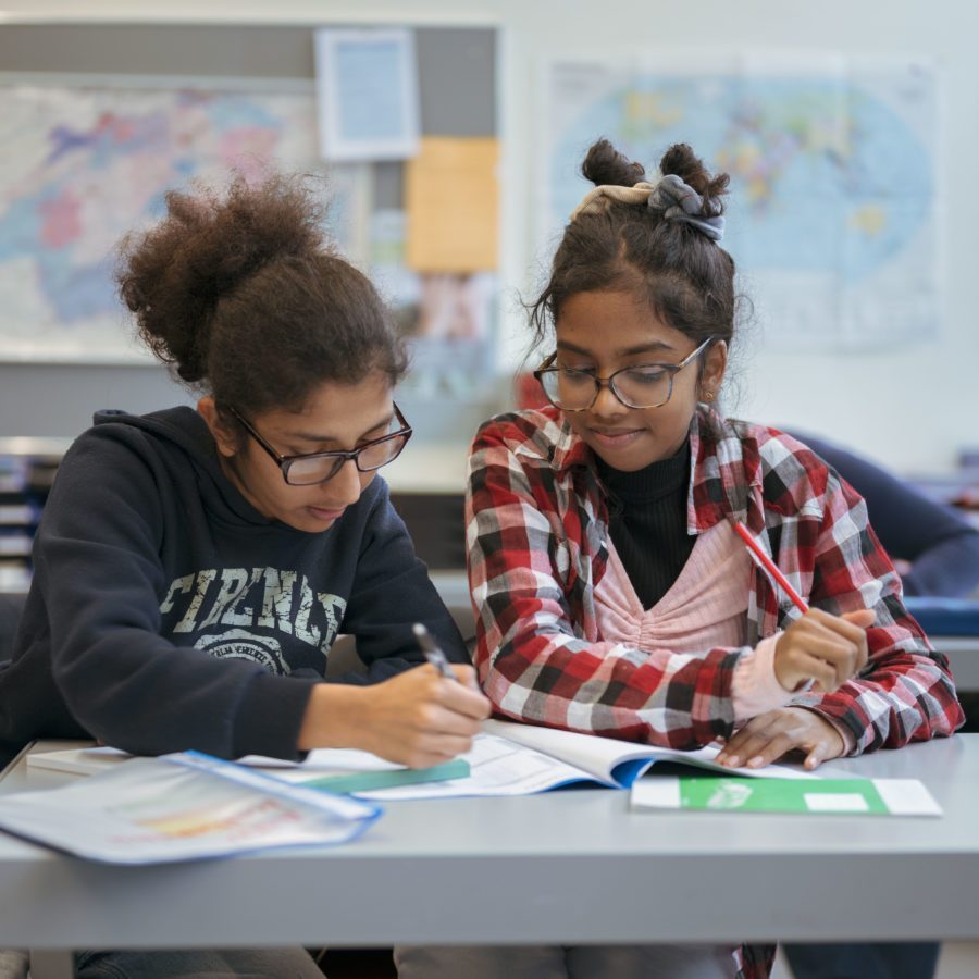 Zwei Kinder sitzen zusammen in der Schule und lösen eine Aufgabe