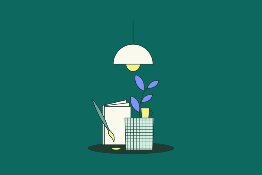 Zeichenblock neben einer Topfpflanze beleuchtet von einer Lampe